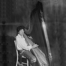 A seated Arthur "Harpo" Marx is playing one of his harps.  Family sources say that his two Lyon & Healy Gold-Gilt Concert Grand, model #24 harps were donated to Israeli orchestras after his death.